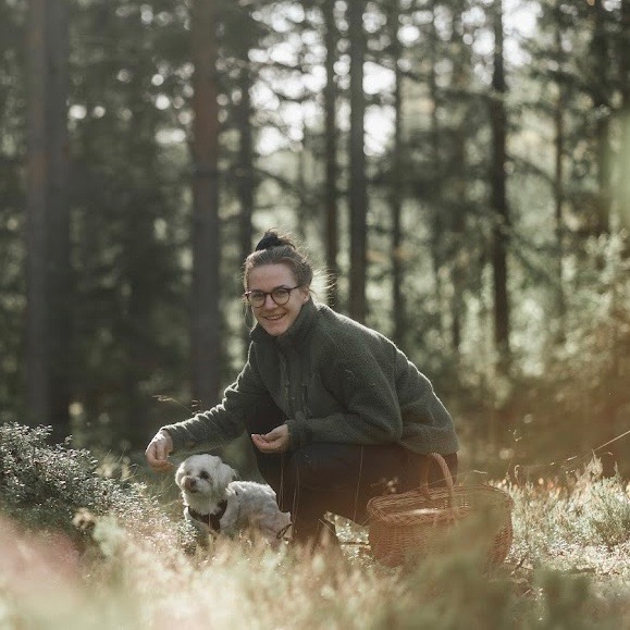 Karin Danelius, administratör och verksamhetsutvecklare på KFUM Ängsholmen, plockar bär i skogen.